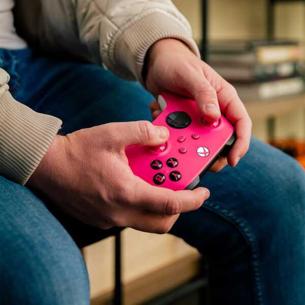 Person holding a vibrant pink Xbox Series X wireless controller.