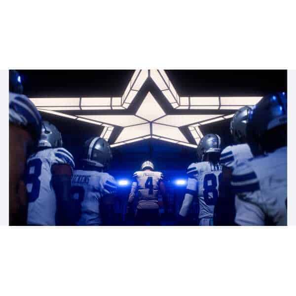 Football players entering the field through a star-shaped tunnel.