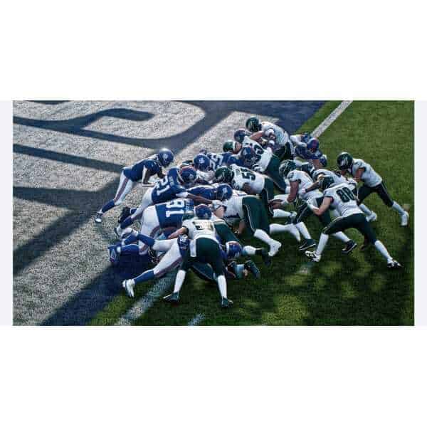 Football players in a game, pushing for yardage on the field.