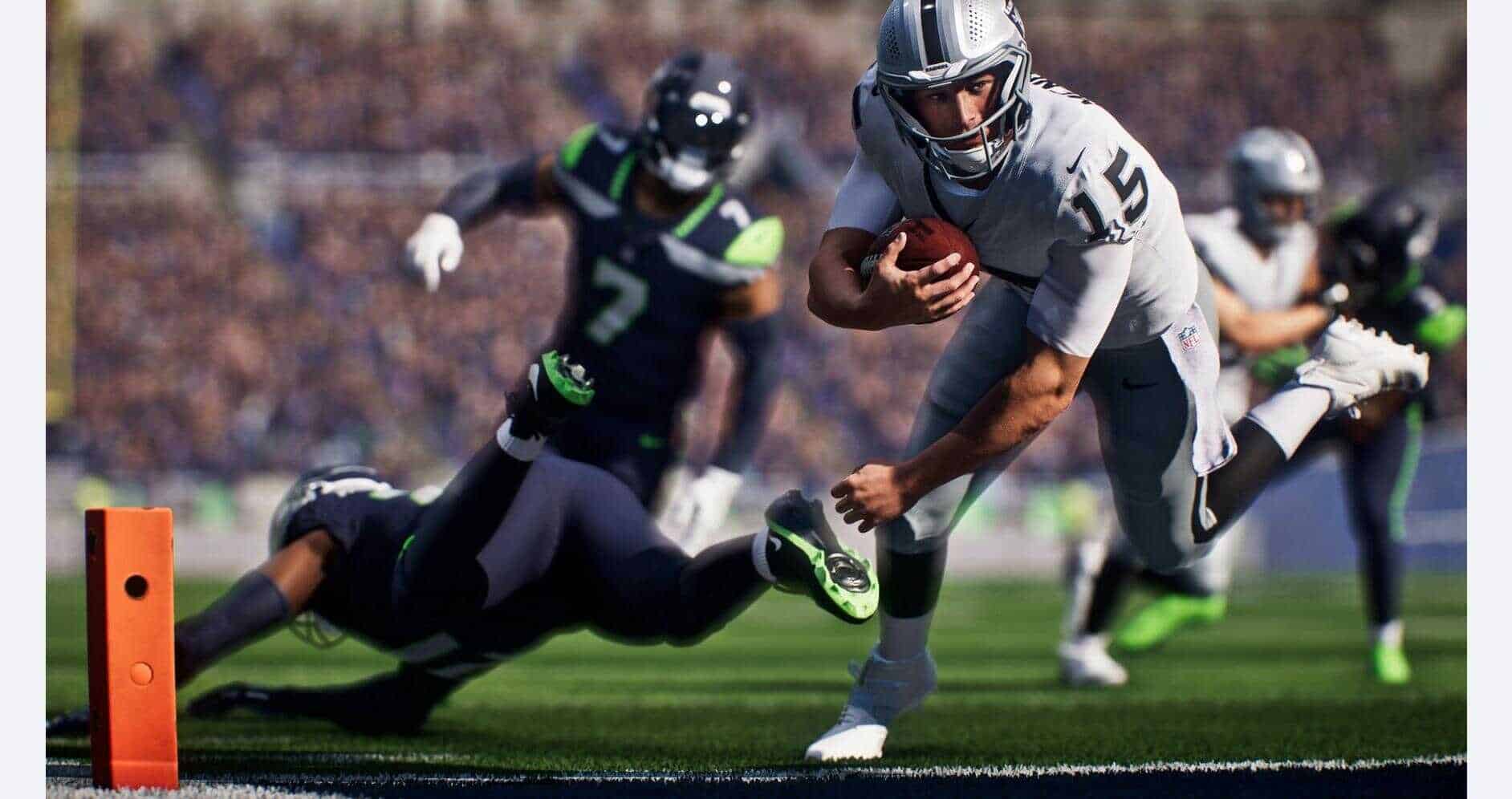 Football player running with ball near end zone, evading defenders.