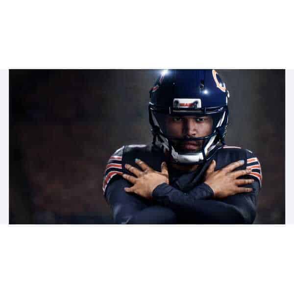 Football player in helmet and uniform, focused and ready for action.