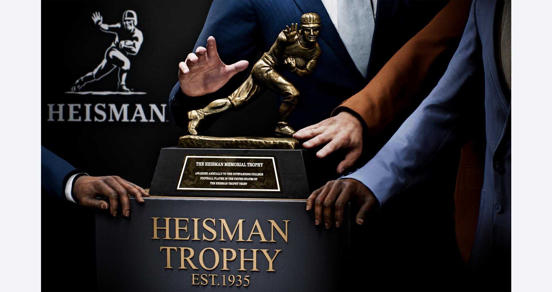 Heisman Trophy award presented at a formal event with people in suits.