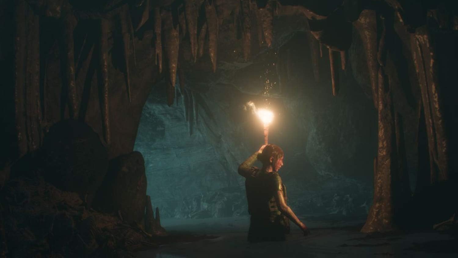 Adventurer exploring a dark cave with torchlight in a game environment.