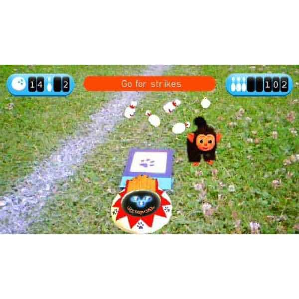 EyePet virtual pet game with a monkey character and interactive elements on grass.