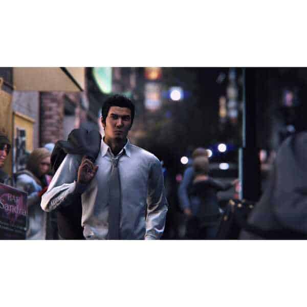 A man in business attire walking on a busy city street at dusk.