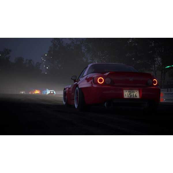 Racing car with red paint and custom wheels on a dark city street at night.