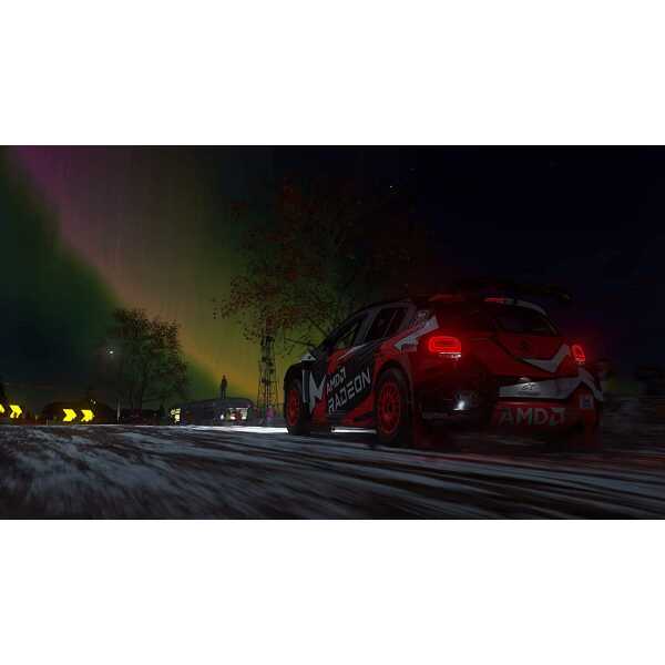 High-performance rally car racing at night with vibrant northern lights in the background.