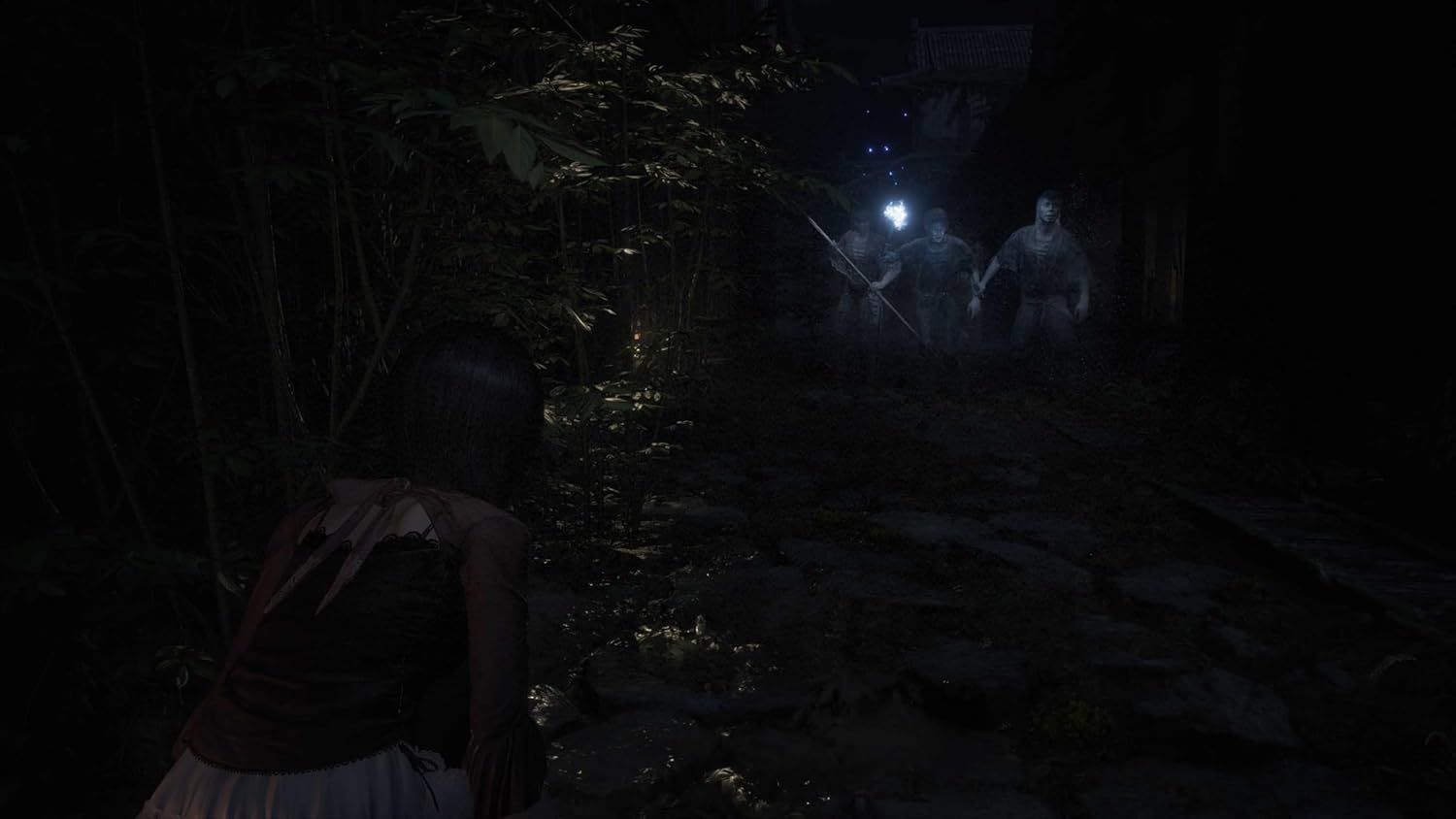 Nighttime horror game scene with two characters approaching a dark, eerie forest path illuminated by.