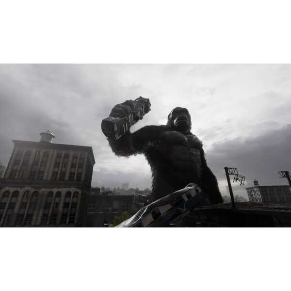 Giant gorilla statue holding a bus in an urban cityscape during cloudy weather.