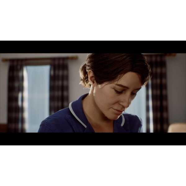 Close-up of a woman with short brown hair looking down, in a dimly lit room.