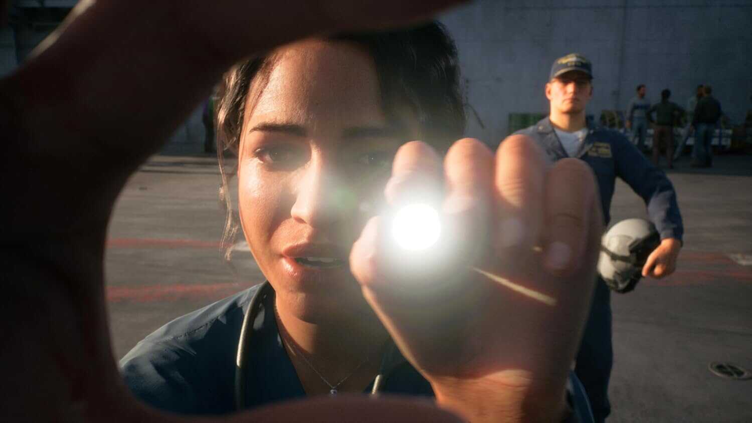 Female pilot holding a flashlight with a male pilot in the background.