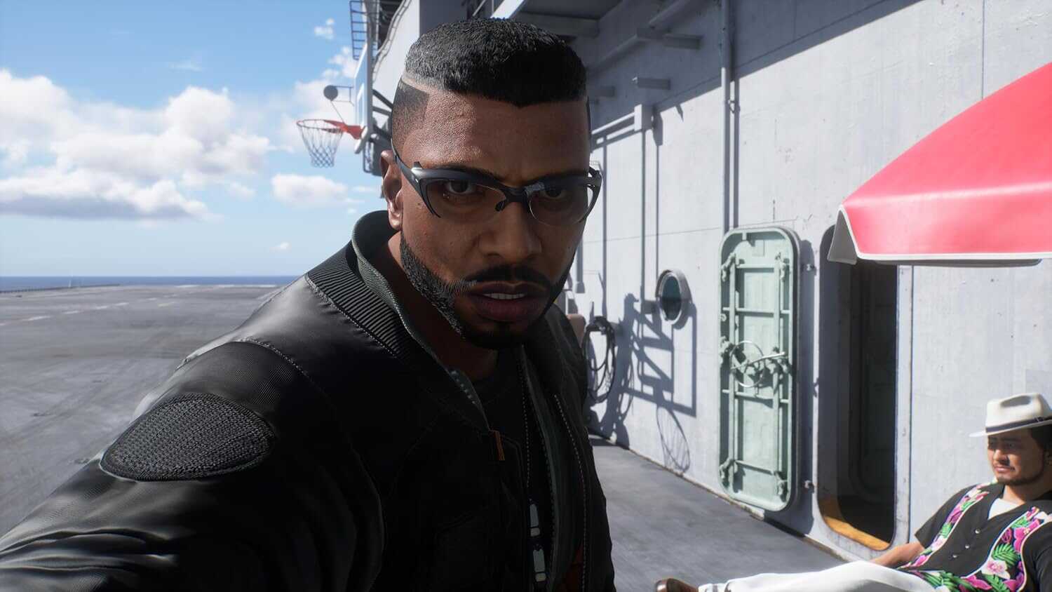 Close-up of a man on an aircraft carrier deck with sunglasses.