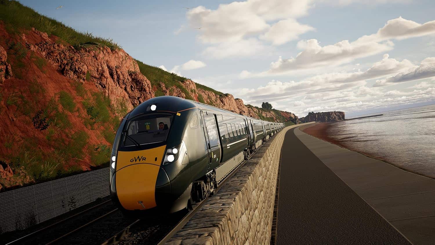 Modern train traveling along a scenic coastal railway route at sunset.