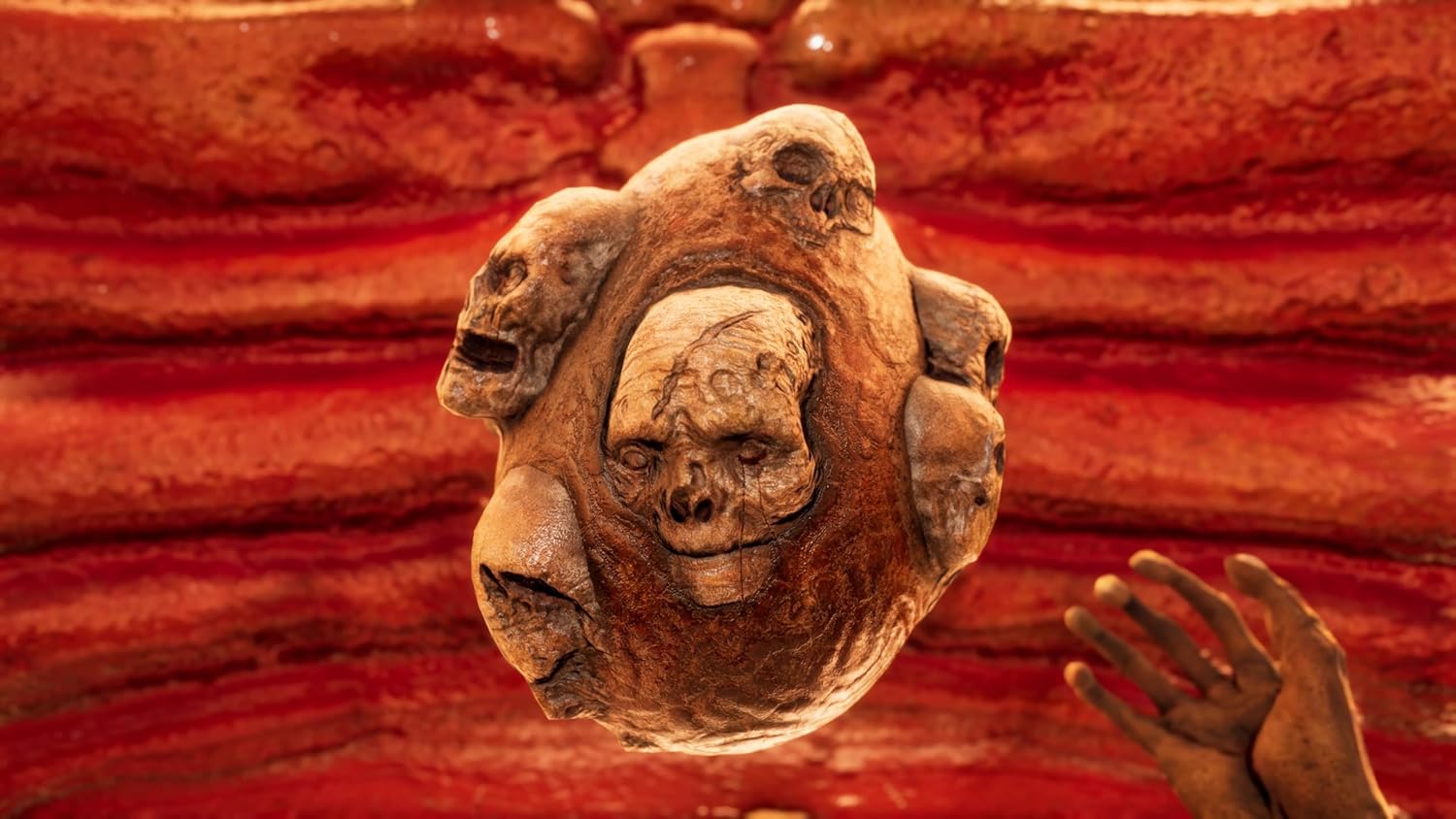 Ancient skull carving with multiple faces, symbolizing consciousness and death.