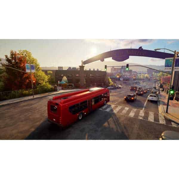 A red bus driving through city streets during sunset, showcasing vibrant urban scenery and traffic.