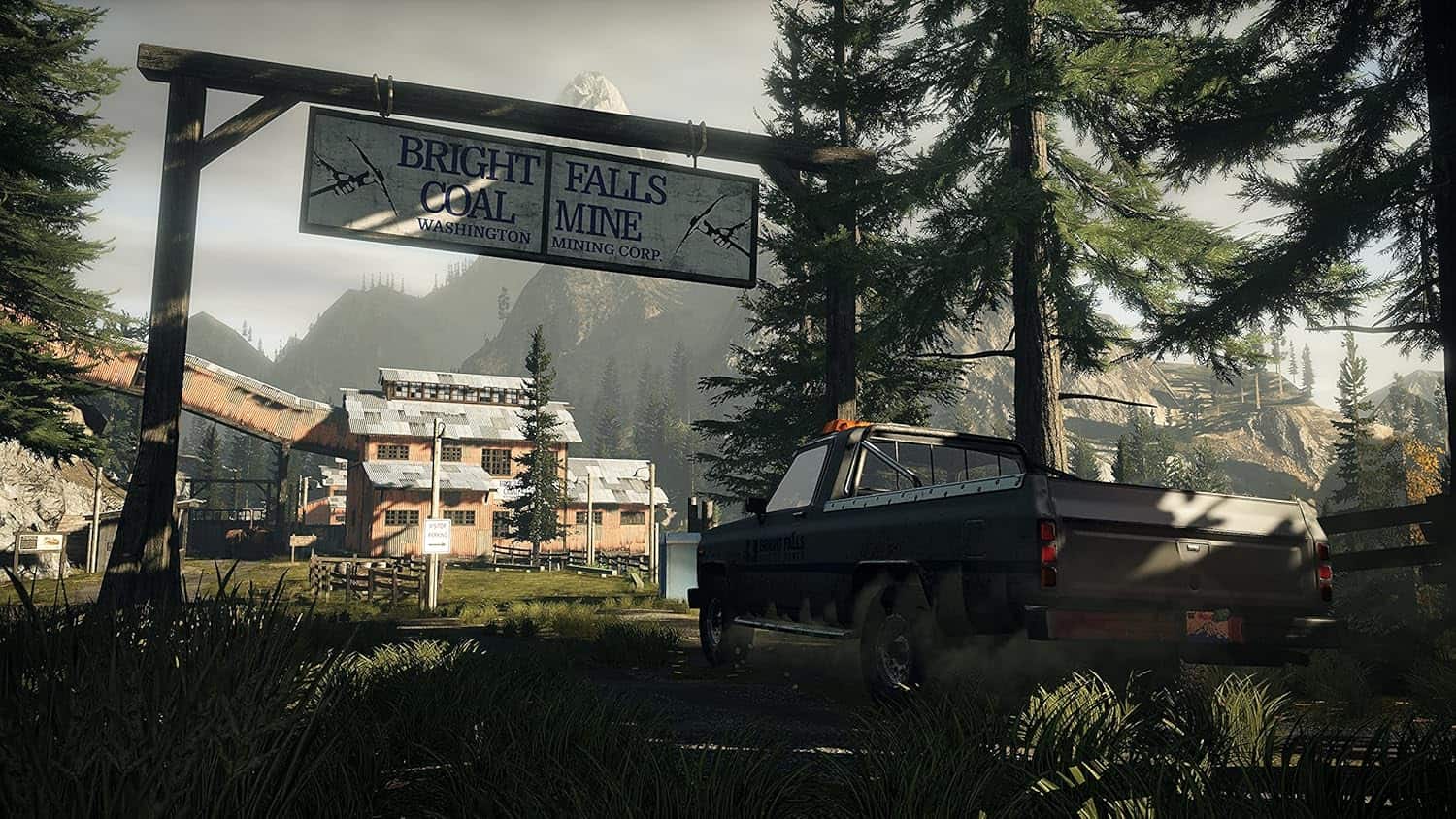 Mining town with a truck and signboard in a forested mountain area.