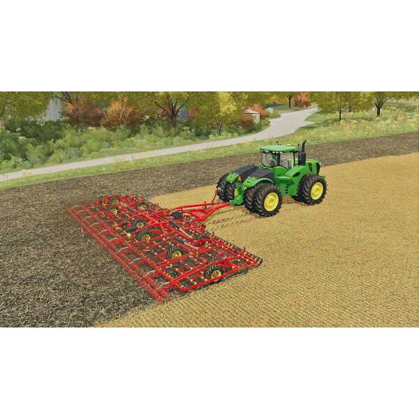 Green tractor with red cultivator working on farmland in Farming Simulator 22.