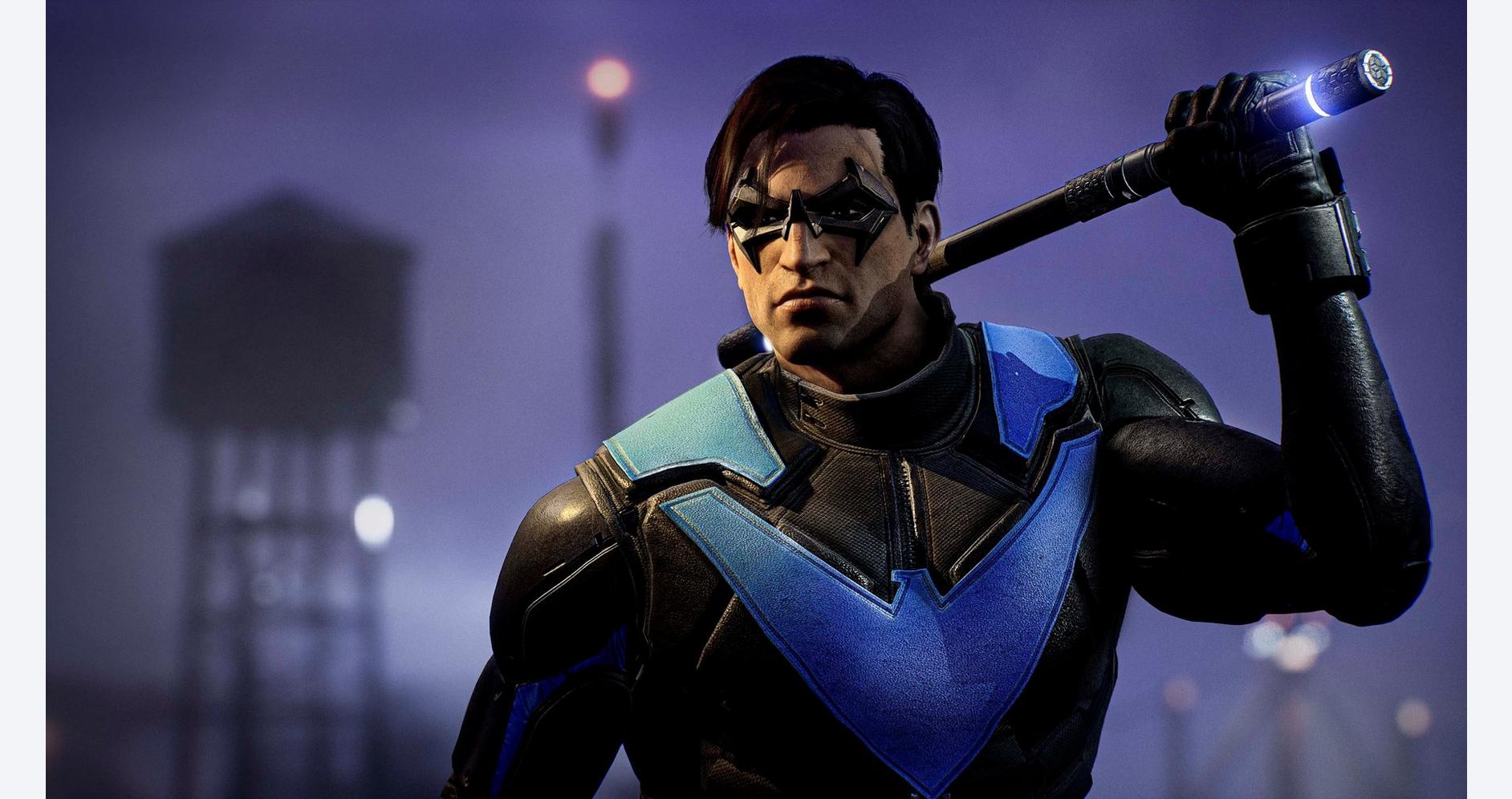 A man in futuristic armor holding a glowing weapon in a dark, urban environment.