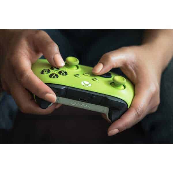 Person holding a bright green Xbox Series X wireless controller with black accents.